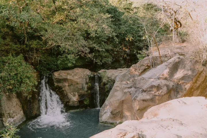 a waterfall with trees in the background