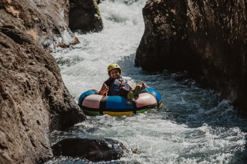 a person in a raft on top of a rock