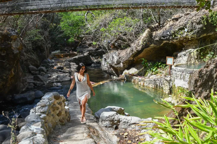 a person sitting on a rock next to a waterfall