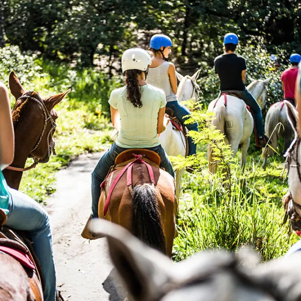 Group traveling by horseback acrossHacienda Guachipelin