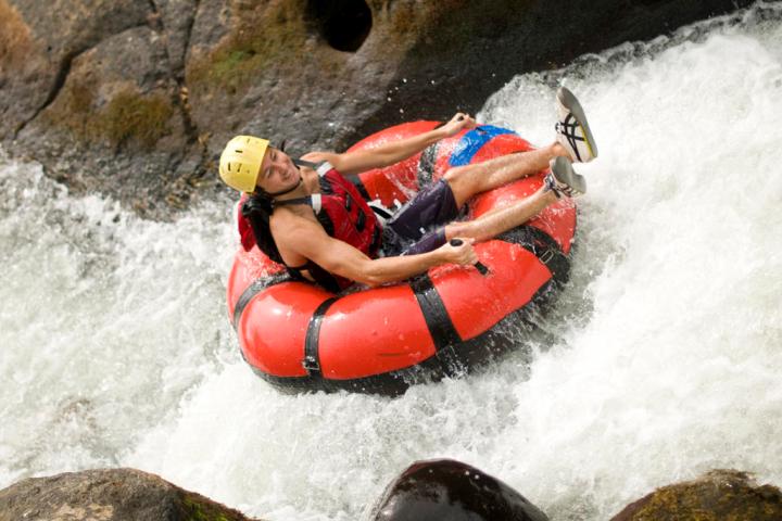 a man riding a wave on a raft in a body of water