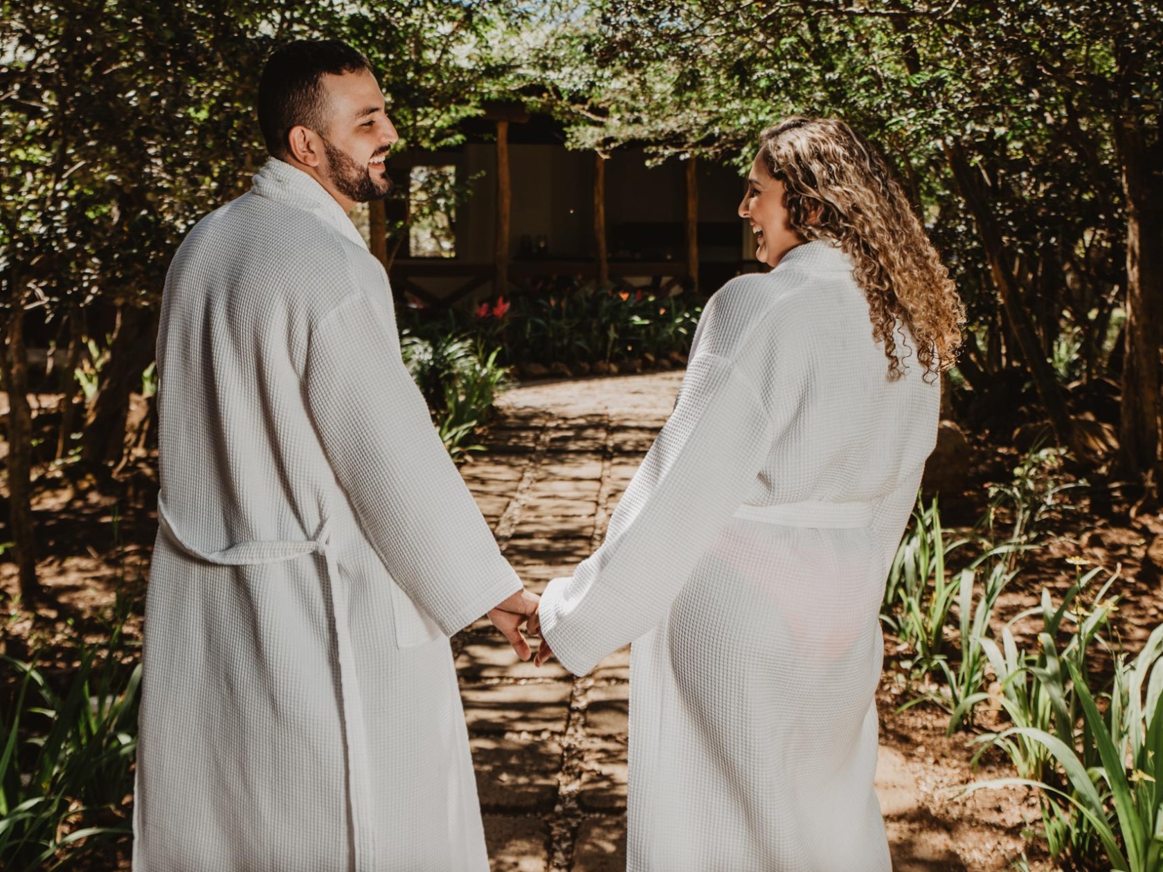 a man and a woman standing in front of a tree