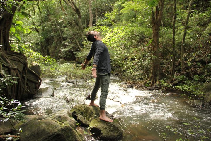 a man standing next to a forest