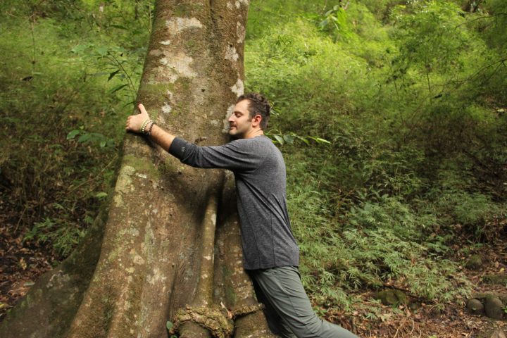 a man standing next to a tree