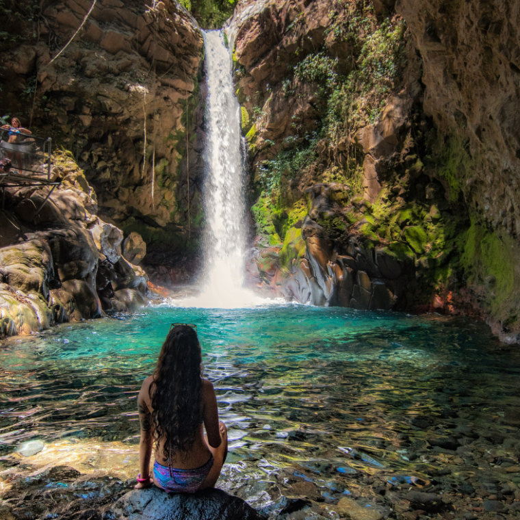a person standing next to a waterfall