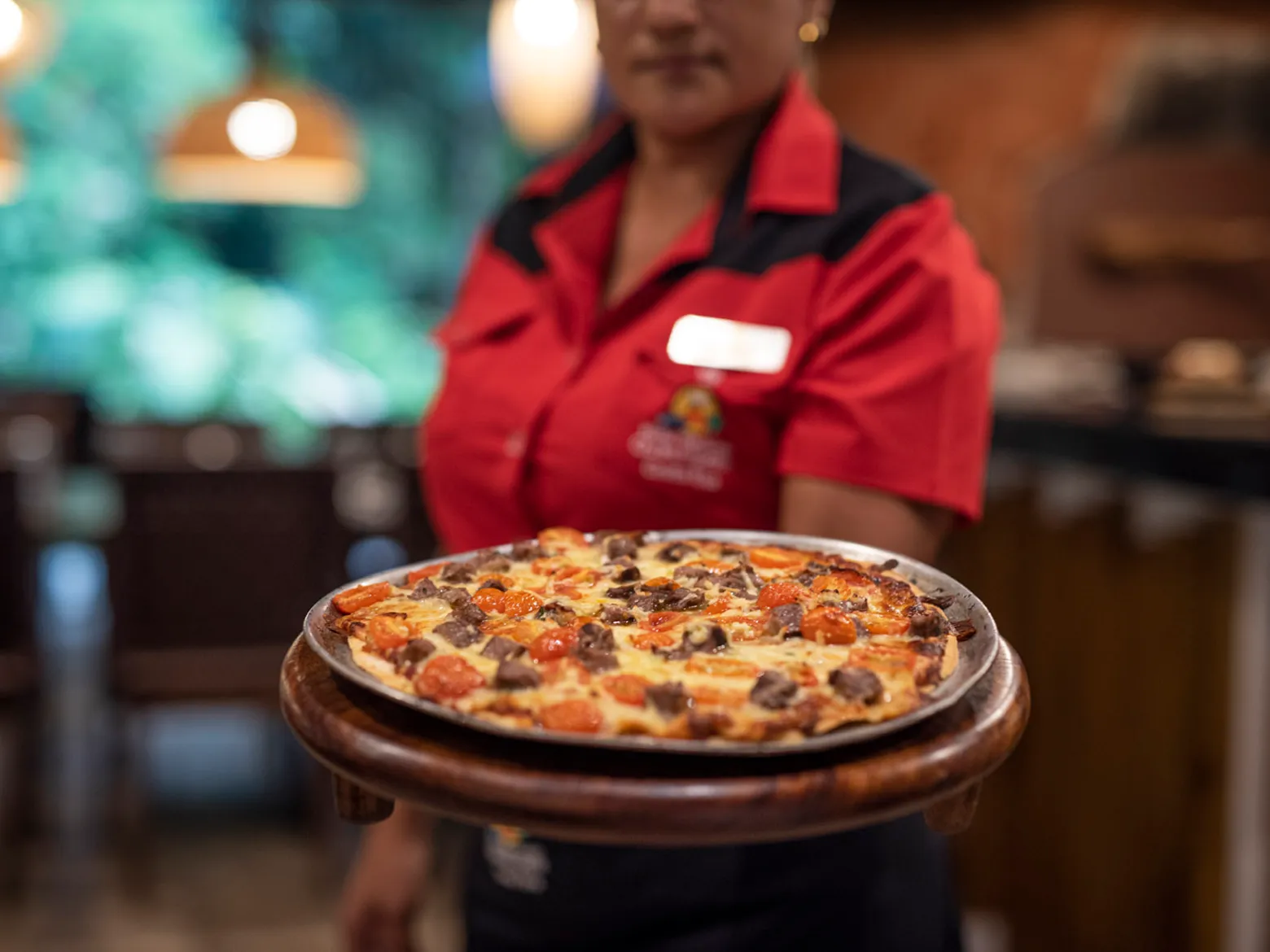 a person standing in front of a pizza