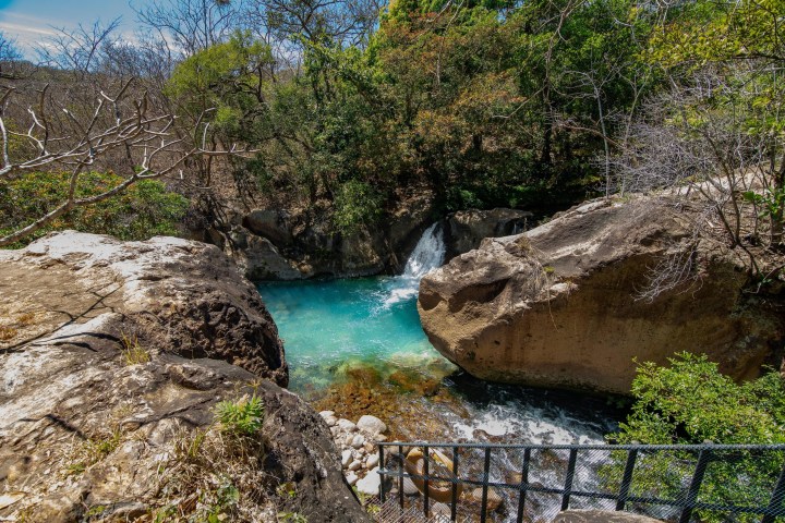 a close up of a rock next to a waterfall
