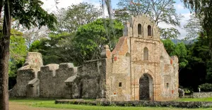 a large stone building with grass in front of a house