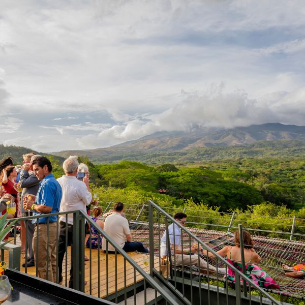 People socializing on a rooftop with a mountain view.
