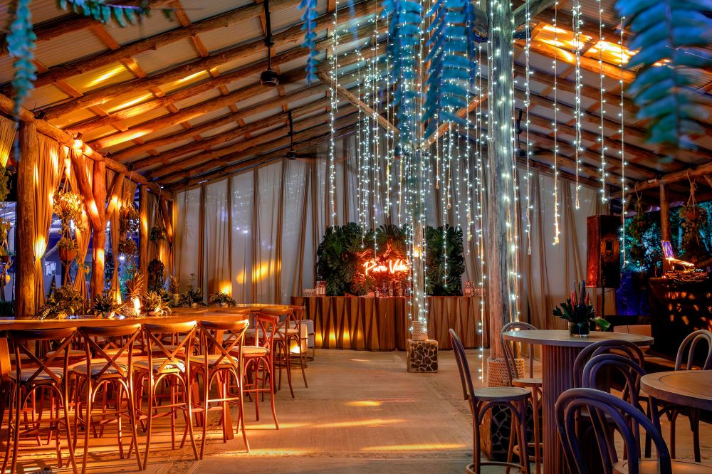 Decorated rustic event space with string lights and wooden furniture.